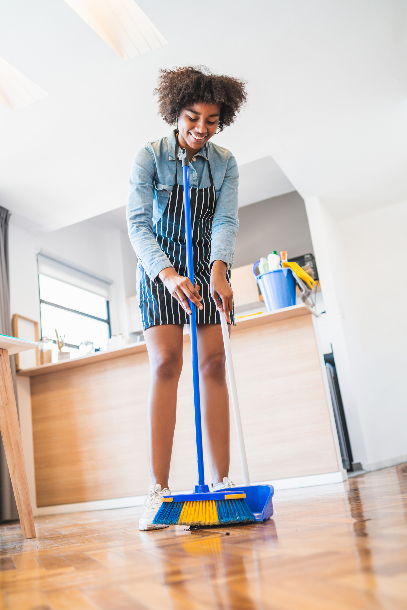 Woman Sweeping the House Floor with a Broom 